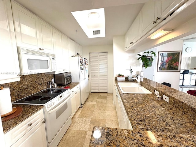 808 Brickell Key Dr Unit 1103, Miami, FL 33131 - kitchen featuring white appliances, white cabinets, decorative backsplash, stone tile flooring, and dark stone countertops