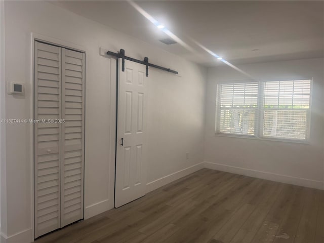 1657 SW 44th Ave, Fort Lauderdale, FL 33317 - unfurnished bedroom featuring wood finished floors and a barn door