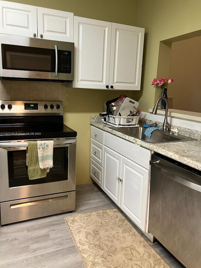 2326 SW 82nd Ter, North Lauderdale, FL 33068 - kitchen featuring stainless steel appliances, white cabinets, light wood finished floors, and light countertops
