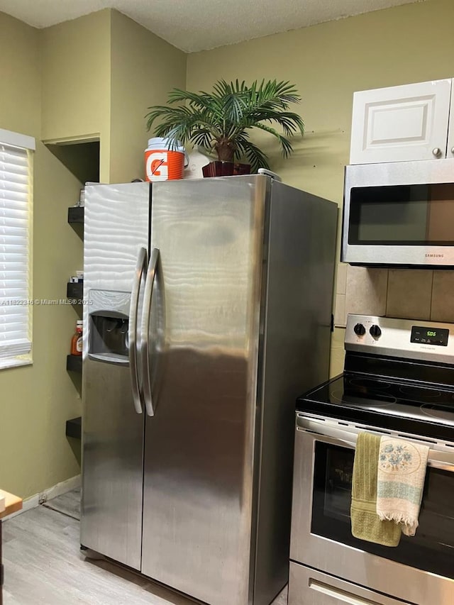 2326 SW 82nd Ter, North Lauderdale, FL 33068 - kitchen with stainless steel appliances, light wood-style floors, and decorative backsplash