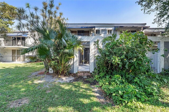 2326 SW 82nd Ter, North Lauderdale, FL 33068 - back of property with stucco siding, a lawn, and a balcony