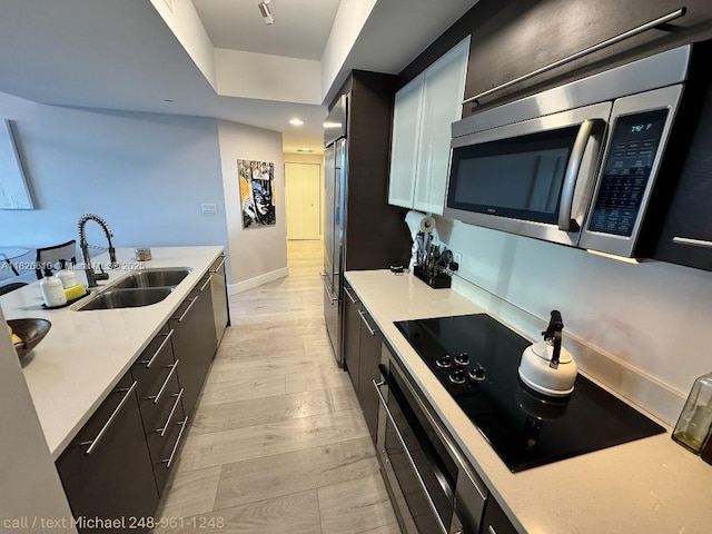 500 Brickell Ave Unit 3803, Miami, FL 33131 - kitchen featuring stainless steel microwave, wall oven, light countertops, light wood-style floors, and black electric stovetop