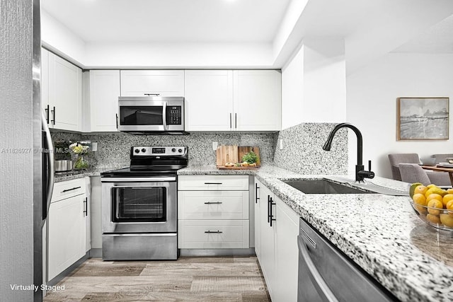 8365 SW 152nd Ave Unit C-201, Miami, FL 33193 - kitchen with stainless steel appliances, light wood-style floors, white cabinets, and light stone counters