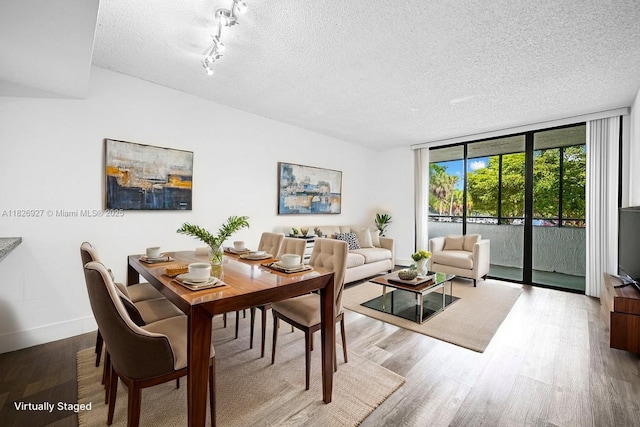 8365 SW 152nd Ave Unit C-201, Miami, FL 33193 - dining space featuring a textured ceiling, wood finished floors, and a wall of windows