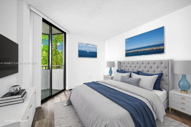 8365 SW 152nd Ave Unit C-201, Miami, FL 33193 - bedroom featuring access to outside, a textured ceiling, and wood finished floors