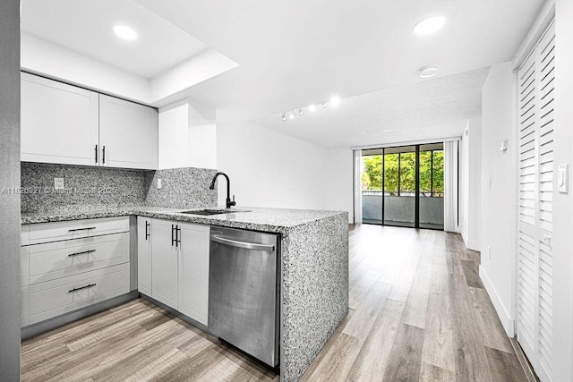 8365 SW 152nd Ave Unit C-201, Miami, FL 33193 - kitchen with stainless steel dishwasher, a peninsula, open floor plan, light stone countertops, and light wood-style flooring
