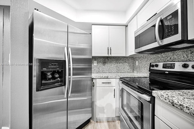 8365 SW 152nd Ave Unit C-201, Miami, FL 33193 - kitchen featuring appliances with stainless steel finishes, white cabinets, light stone counters, and tasteful backsplash