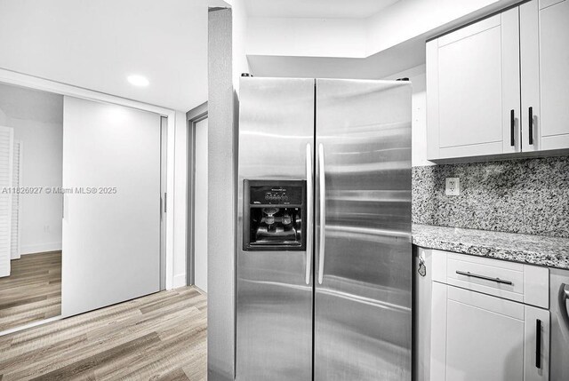 8365 SW 152nd Ave Unit C-201, Miami, FL 33193 - kitchen featuring stainless steel fridge with ice dispenser, light wood-style flooring, white cabinetry, light stone counters, and recessed lighting