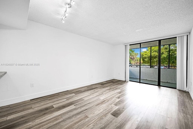 8365 SW 152nd Ave Unit C-201, Miami, FL 33193 - spare room with a textured ceiling, floor to ceiling windows, and wood finished floors