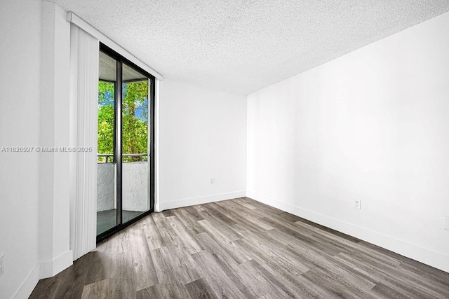 8365 SW 152nd Ave Unit C-201, Miami, FL 33193 - unfurnished room featuring wood finished floors, a textured ceiling, and a wall of windows