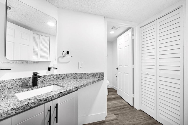 8365 SW 152nd Ave Unit C-201, Miami, FL 33193 - bathroom with a closet, a textured ceiling, vanity, wood finished floors, and recessed lighting
