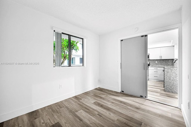 8365 SW 152nd Ave Unit C-201, Miami, FL 33193 - unfurnished room with light wood-style flooring and a textured ceiling