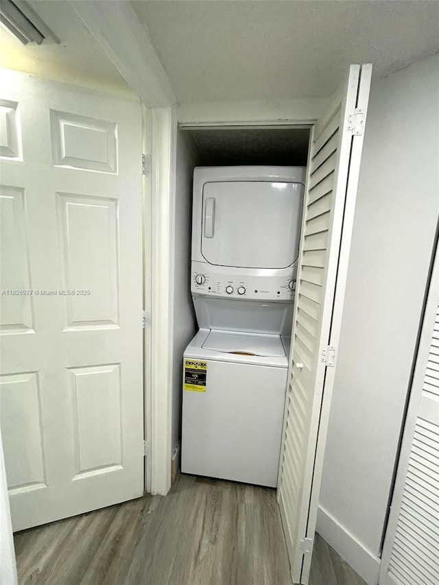 8365 SW 152nd Ave Unit C-201, Miami, FL 33193 - washroom with stacked washer and clothes dryer and wood finished floors