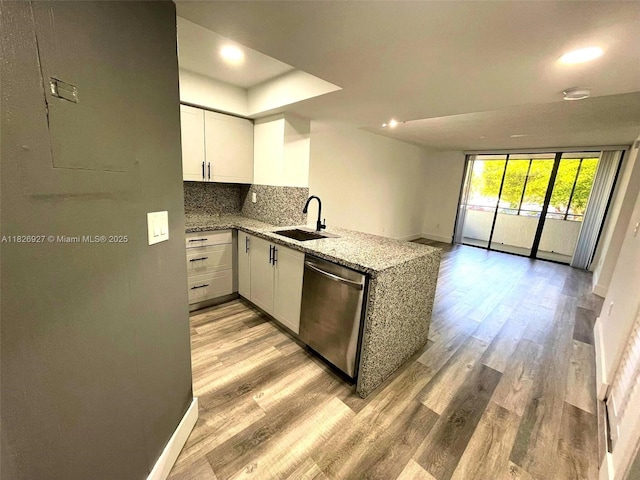 8365 SW 152nd Ave Unit C-201, Miami, FL 33193 - kitchen featuring stainless steel dishwasher, a peninsula, light wood-type flooring, light stone countertops, and decorative backsplash