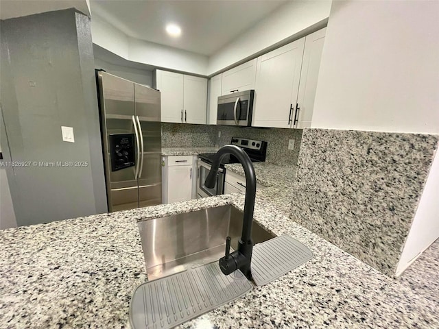 8365 SW 152nd Ave Unit C-201, Miami, FL 33193 - kitchen with stainless steel appliances, light stone countertops, decorative backsplash, white cabinetry, and recessed lighting