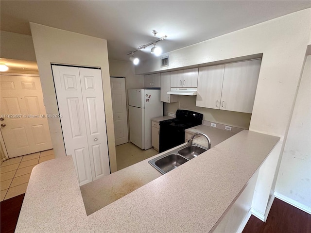 11185 SW 6th St Unit 303, Pembroke Pines, FL 33025 - kitchen with freestanding refrigerator, black range with electric cooktop, under cabinet range hood, white cabinetry, and light countertops