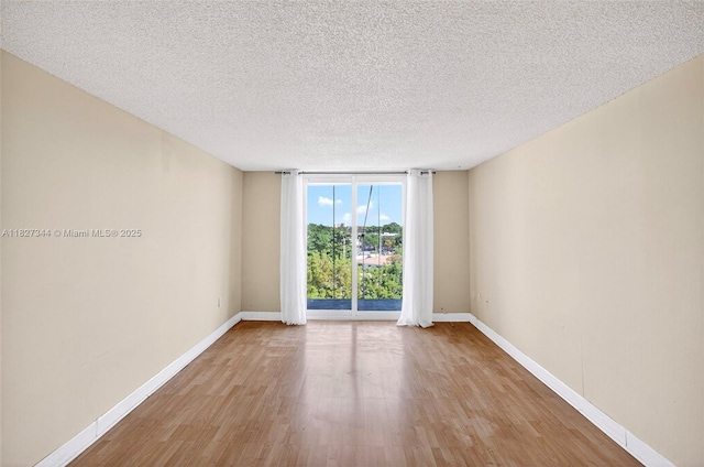 16851 NE 23rd Ave Unit A619, North Miami Beach, FL 33160 - spare room with wood finished floors, a textured ceiling, and a wall of windows