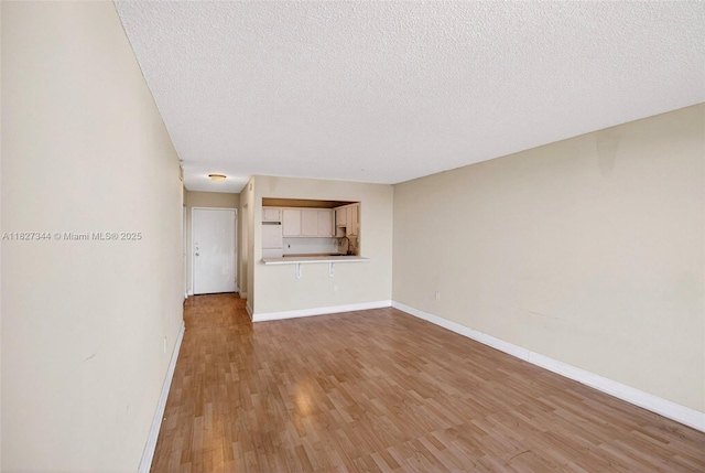 16851 NE 23rd Ave Unit A619, North Miami Beach, FL 33160 - unfurnished living room featuring light wood-type flooring and a textured ceiling
