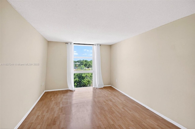 16851 NE 23rd Ave Unit A619, North Miami Beach, FL 33160 - spare room featuring light wood-type flooring, expansive windows, and a textured ceiling