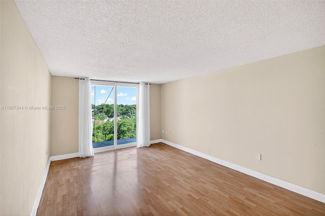 16851 NE 23rd Ave Unit A619, North Miami Beach, FL 33160 - spare room with a textured ceiling, wood finished floors, and a wall of windows