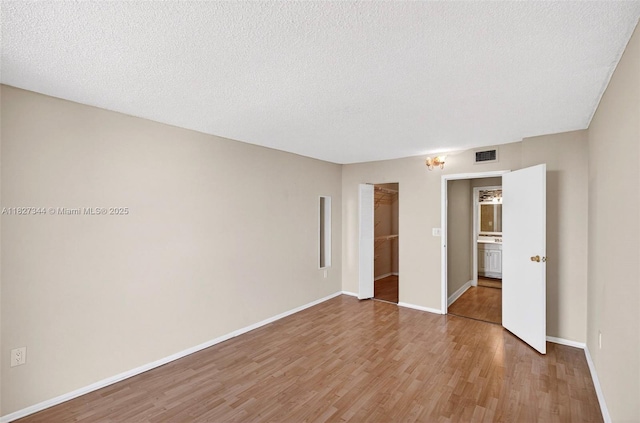 16851 NE 23rd Ave Unit A619, North Miami Beach, FL 33160 - unfurnished bedroom with wood finished floors, a spacious closet, a closet, and a textured ceiling