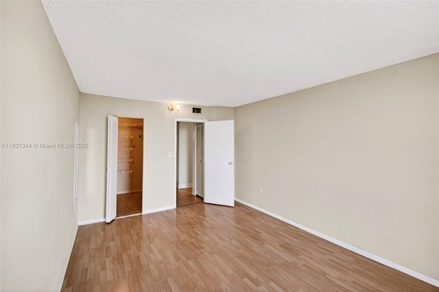 16851 NE 23rd Ave Unit A619, North Miami Beach, FL 33160 - unfurnished bedroom featuring light wood-style flooring and a textured ceiling