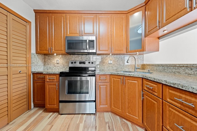 20155 E Oakmont Cir, Hialeah, FL 33015 - kitchen with appliances with stainless steel finishes, light wood-style floors, and light stone counters
