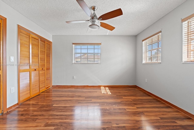 20155 E Oakmont Cir, Hialeah, FL 33015 - unfurnished bedroom with multiple windows, wood finished floors, a textured ceiling, and a ceiling fan