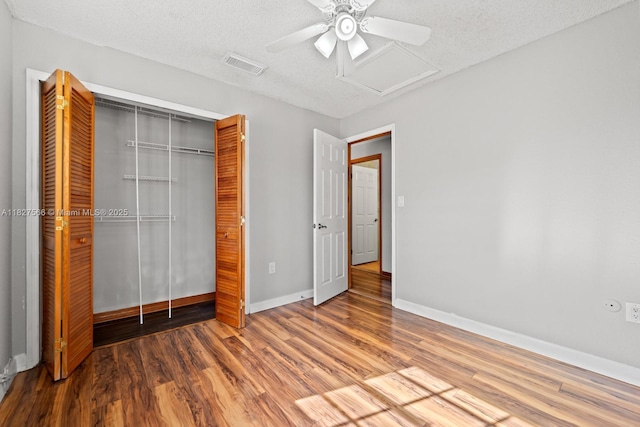 20155 E Oakmont Cir, Hialeah, FL 33015 - unfurnished bedroom with attic access, a closet, wood finished floors, a textured ceiling, and ceiling fan