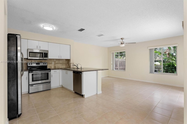 1784 SW 110th Ter, Davie, FL 33324 - kitchen featuring stainless steel appliances, backsplash, a peninsula, open floor plan, and white cabinets