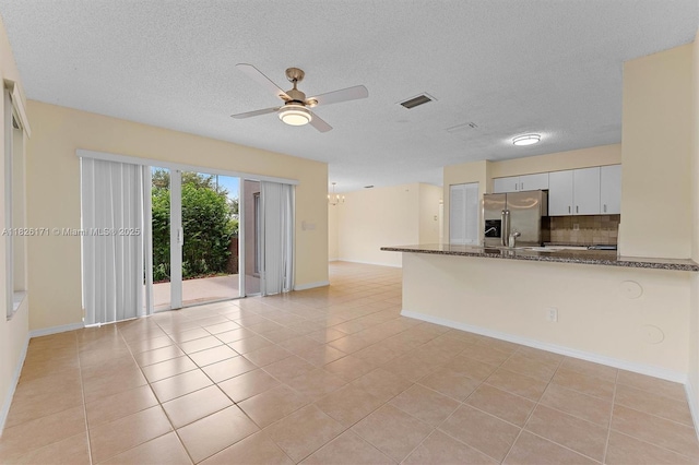 1784 SW 110th Ter, Davie, FL 33324 - kitchen featuring stainless steel fridge, backsplash, a peninsula, dark stone countertops, and a ceiling fan