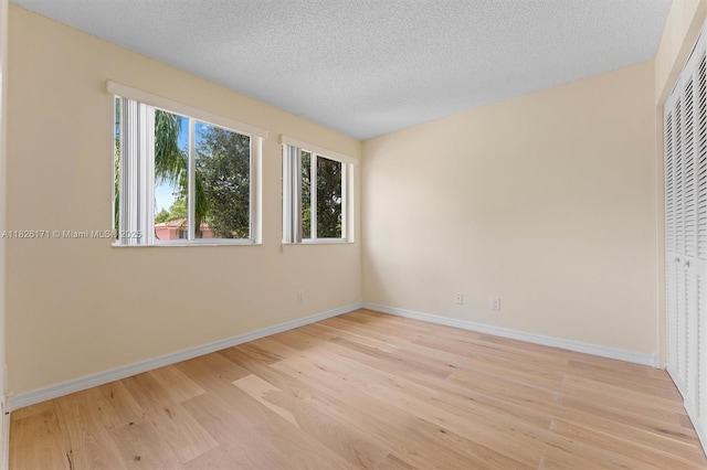 1784 SW 110th Ter, Davie, FL 33324 - unfurnished bedroom with light wood-type flooring, a textured ceiling, and a closet