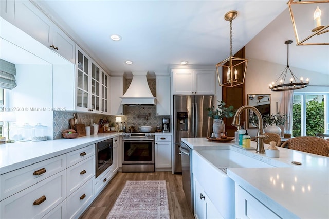 13765 SW 147th Cir Ln Unit 2-24, Miami, FL 33186 - kitchen with custom range hood, appliances with stainless steel finishes, a chandelier, light wood-style floors, and white cabinetry