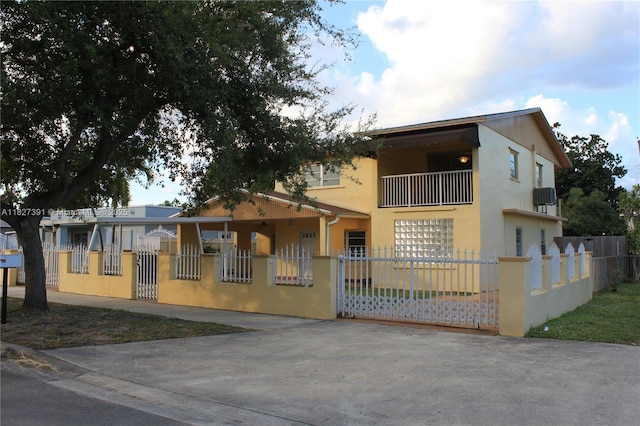 971 E 18th St, Hialeah, FL 33013 - view of front of home with a fenced front yard, a balcony, a gate, and stucco siding