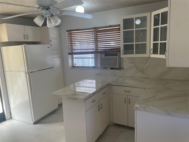 971 E 18th St, Hialeah, FL 33013 - kitchen featuring freestanding refrigerator, a peninsula, glass insert cabinets, a ceiling fan, and white cabinets