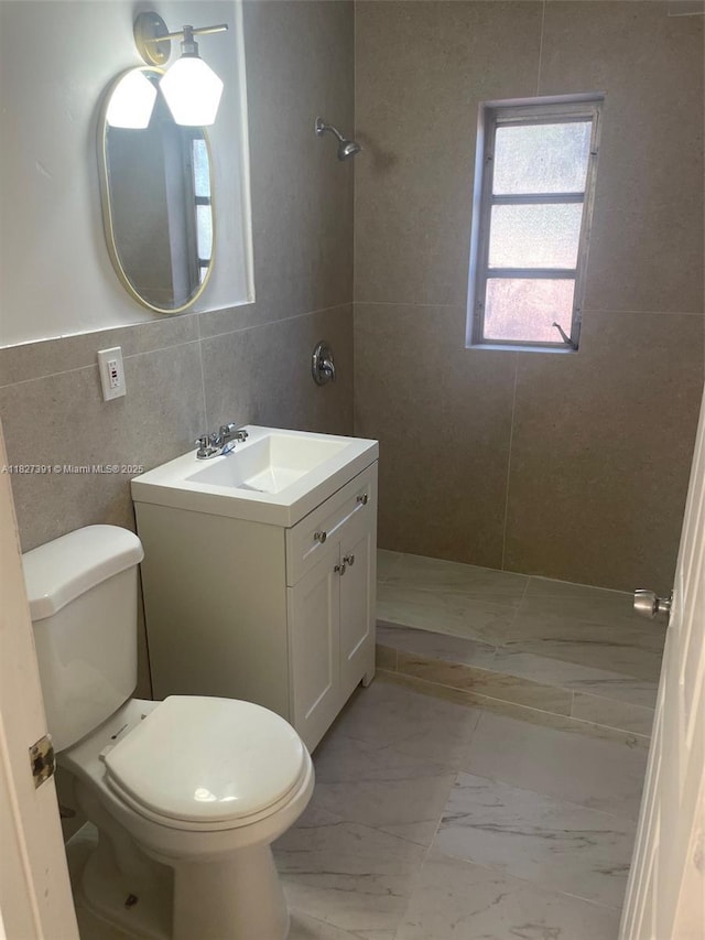 971 E 18th St, Hialeah, FL 33013 - bathroom featuring tiled shower, tile walls, vanity, and marble look tiles