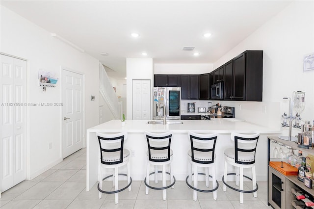 10628 W 33rd Way, Hialeah, FL 33018 - kitchen with stainless steel appliances, light countertops, a breakfast bar area, a peninsula, and light tile patterned floors