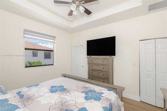 10628 W 33rd Way, Hialeah, FL 33018 - bedroom with light wood finished floors, a tray ceiling, ceiling fan, and a closet