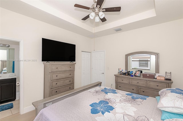 10628 W 33rd Way, Hialeah, FL 33018 - bedroom with a tray ceiling, a ceiling fan, and ensuite bathroom