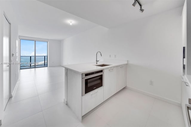 501 NE 31st St Unit 2005, Miami, FL 33137 - kitchen with stainless steel oven, a peninsula, light countertops, open floor plan, and modern cabinets