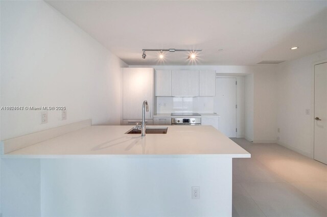 501 NE 31st St Unit 2005, Miami, FL 33137 - kitchen with a peninsula, oven, light countertops, rail lighting, and white cabinets