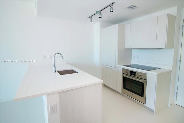 501 NE 31st St Unit 2005, Miami, FL 33137 - kitchen with stainless steel oven, black electric cooktop, a peninsula, track lighting, and modern cabinets