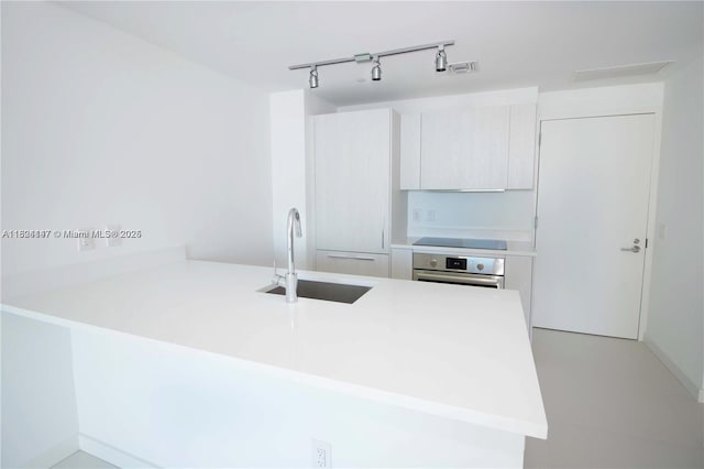 501 NE 31st St Unit 2005, Miami, FL 33137 - kitchen with a peninsula, stainless steel oven, modern cabinets, light countertops, and track lighting