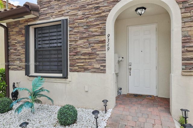9349 W 33rd Way, Hialeah, FL 33018 - doorway to property featuring stone siding and stucco siding