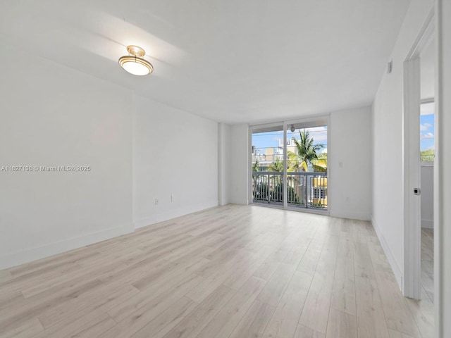 401 Ocean Dr Unit 403, Miami Beach, FL 33139 - spare room with light wood-style floors and a wall of windows