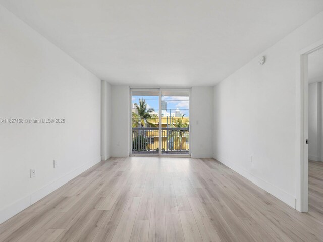 401 Ocean Dr Unit 403, Miami Beach, FL 33139 - spare room with light wood-style floors, a wall of windows, and a smoke detector