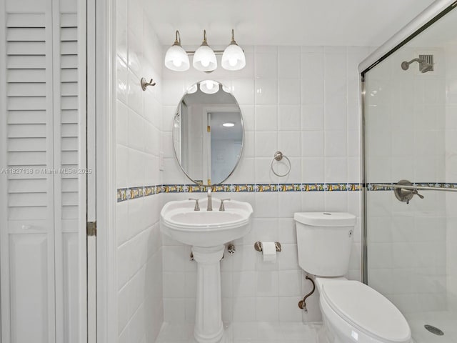 401 Ocean Dr Unit 403, Miami Beach, FL 33139 - bathroom featuring tile walls, a stall shower, and a closet