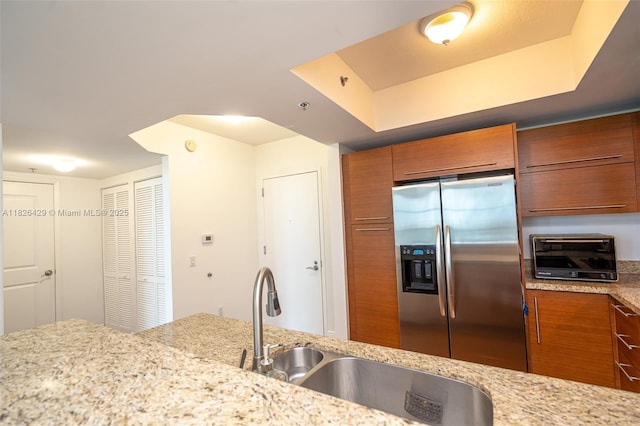 2641 N Flamingo Rd Unit 1603N, Sunrise, FL 33323 - kitchen with stainless steel fridge with ice dispenser, brown cabinetry, and light stone countertops