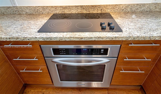 2641 N Flamingo Rd Unit 1603N, Sunrise, FL 33323 - kitchen view of oven, black electric stovetop, and brown cabinets