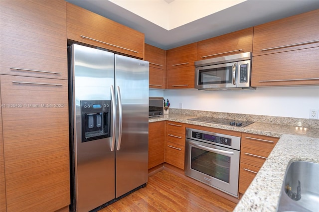 2641 N Flamingo Rd Unit 1603N, Sunrise, FL 33323 - kitchen with appliances with stainless steel finishes, brown cabinets, and light wood-style flooring